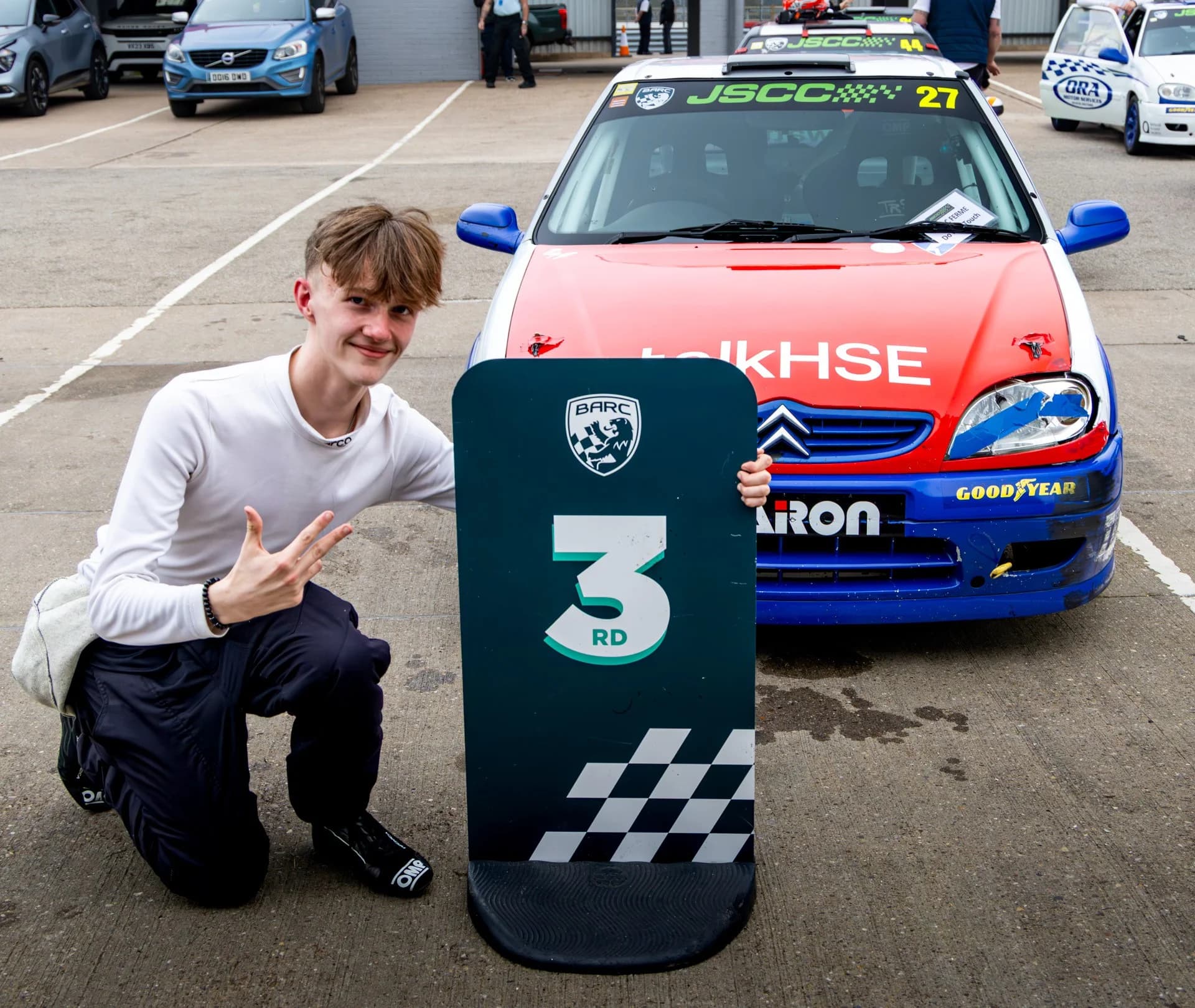 Matthew Swatton crouched by the third position sign after his second P3 finish at Donington Park